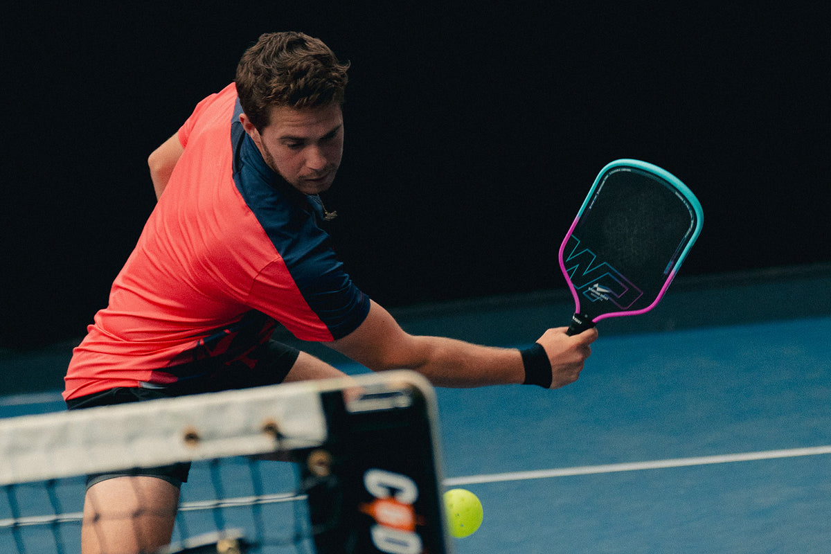 Competitive player testing a Warping Point pickleball paddle on court